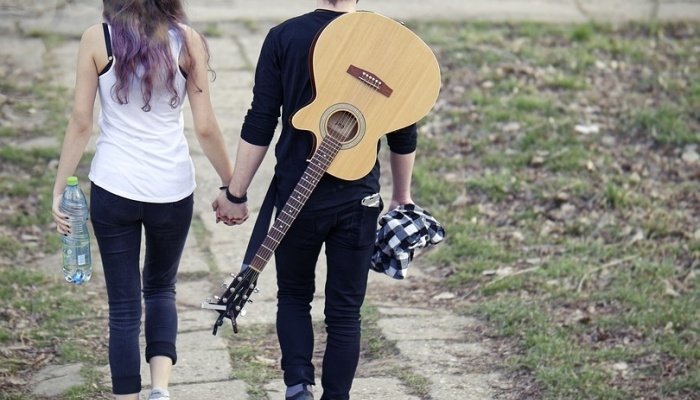 Парень с гитарой гуляет с девушкой